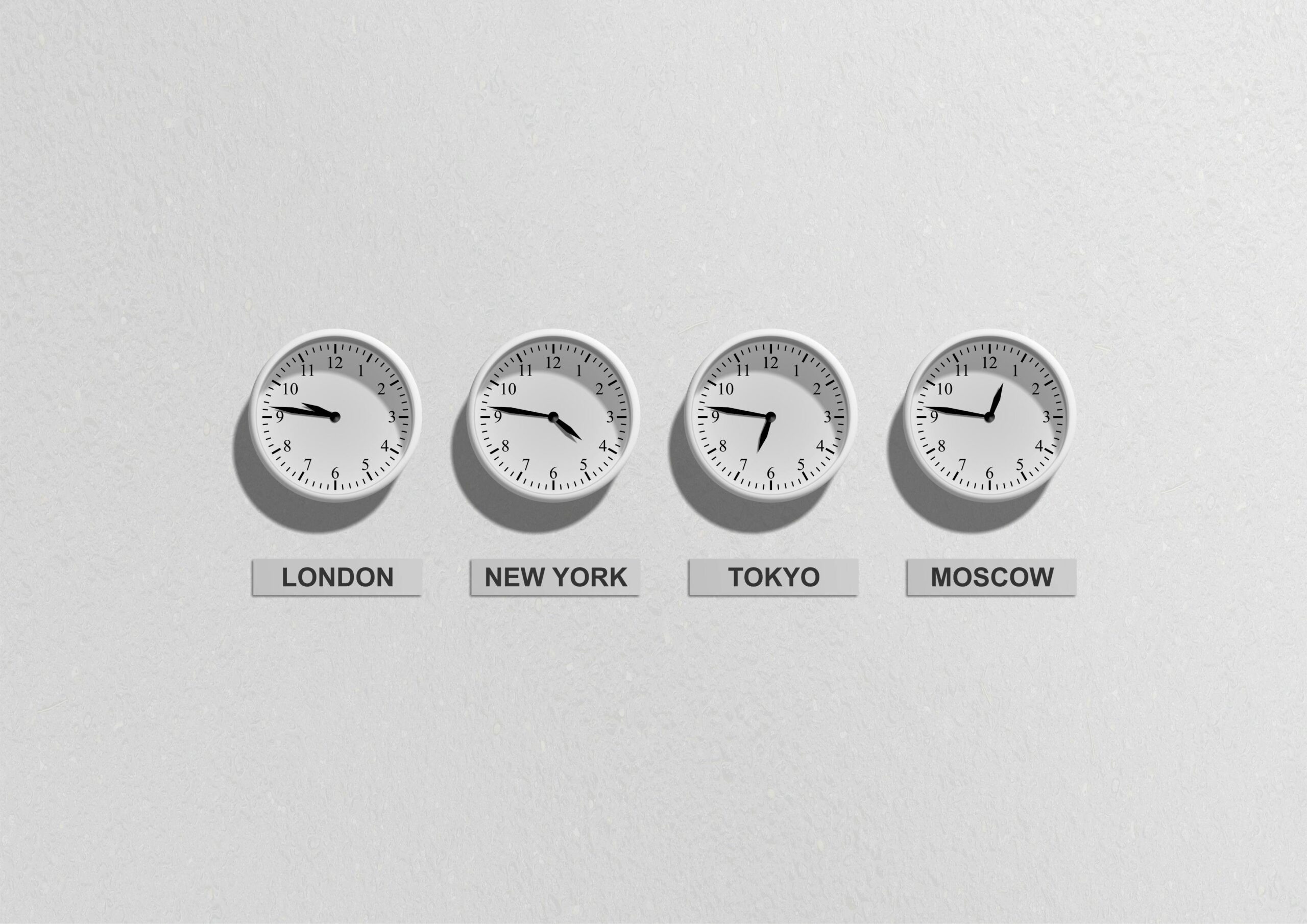 series of clocks with different timezones on a white wall.